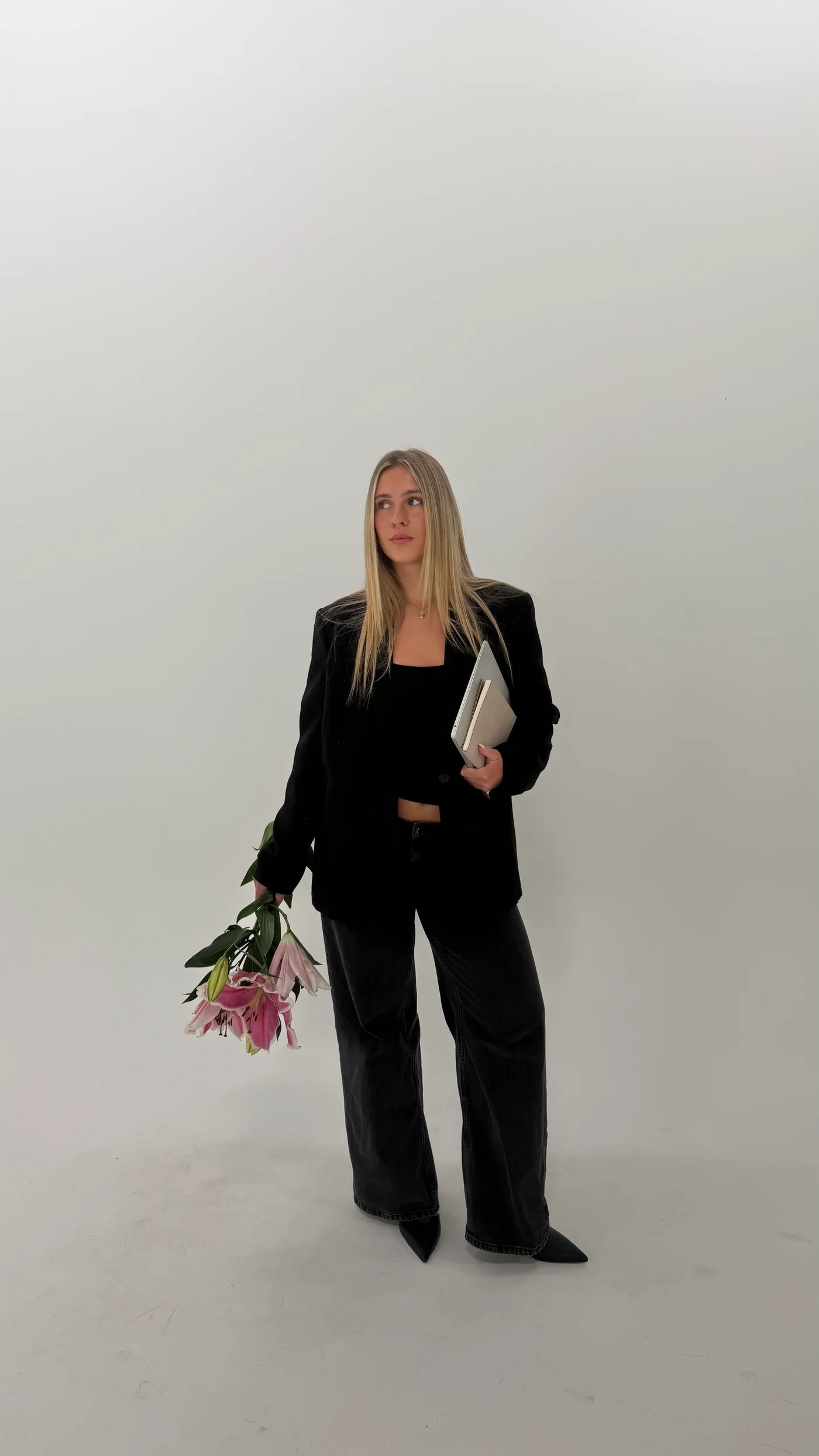 Amelia Daff holding a laptop and pink lilies